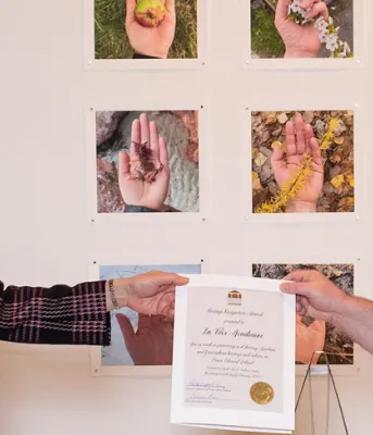 Her Honour Antoinette Perry stands with a man from La Voix Acadienne holding their heritage award