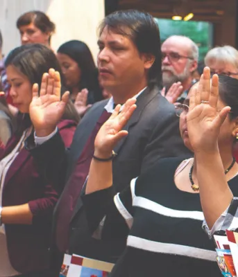 Statement from Premier Dennis King on Human Rights Day image of a group of people standing shoulder to shoulder with one arm - palm out - held at shoulder height