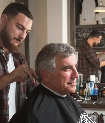The Humble Barber suceeds with help from Self Employ PEI Minister Richard Brown is sitting in a barber chair having his haircut at The Humble Barber