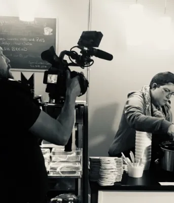 Woman being videoed while working at a cafe