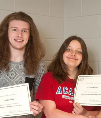 Minister Brown and two students hold winning certificates