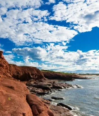Scenic photo of PEI red cliffs and the ocean in the sun