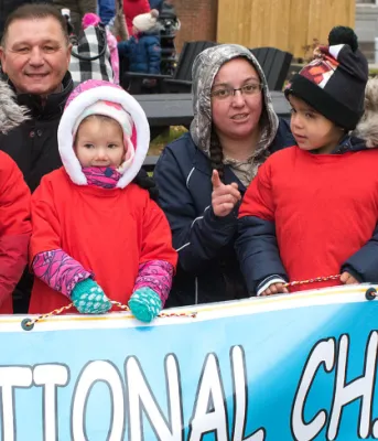 Children and adults stand behind a banner for 2018 National Child Day parade