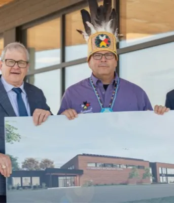 A new recreation centre is coming to Abegweit First Nation image of three people in front of a building holding architectural rendering of a building