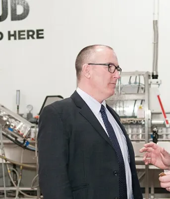 PEI Brewing Company expanding to increase capacity Two people speaking to each other while standing in front of brewing equipment