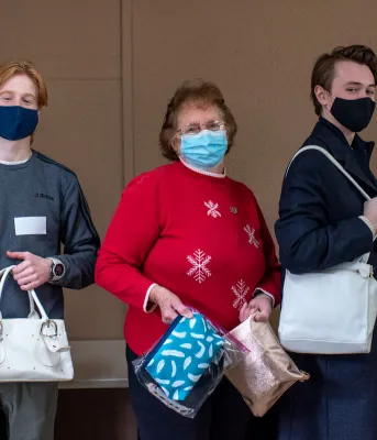 image of three people holding hand bags