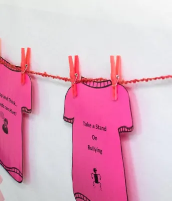 A line of pink shirt cut-outs to promote kindness on Pink Shirt Day