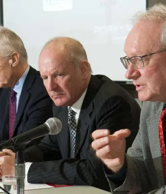 New integrated set of standards for policing Premier MacLauchlan and three others sit at a table discussing the review