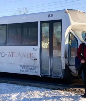 Boy standing beside public transit bus