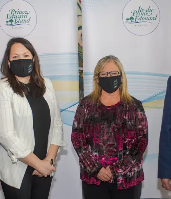 Standing in a row, wearing facemasks: PEI Minister James Aylward, Stratford Town Councilors Jill Burridge and Gail MacDonald, and Federal Minister Lawrence MacAulay
