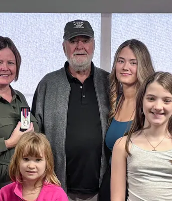 Surrounded by her family, Sue Doucette, provincial palliative home care clinical development coordinator and recipient of the King Charles III medal.