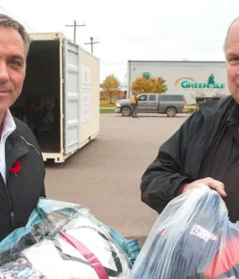 Islanders encouraged to recycle textiles Two men holding bags of textiles for recycling