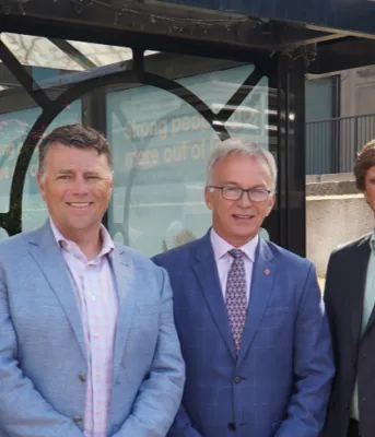 New vehicles to improve public transit services for Charlottetown area residents Five people standing shoulder to shoulder in front of a bus stop