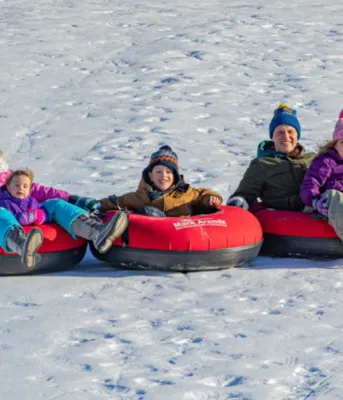 Image of family in tubes on snowy hill