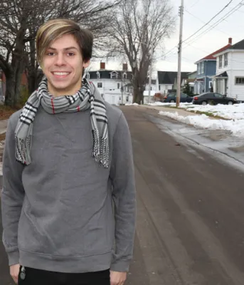 Tyler Murnaghan Tyler Murnaghan stands alone on a snowy city street smiling at the camera.