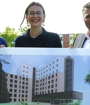 New student housing for University of Prince Edward Island three people holding a picture of a building