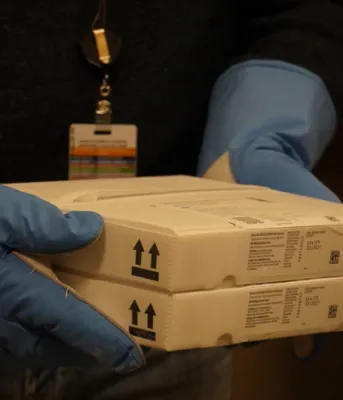 Pfizer COVID-19 vaccine arrives in PEI; Circuit Breaker update Image of a person carrying a package