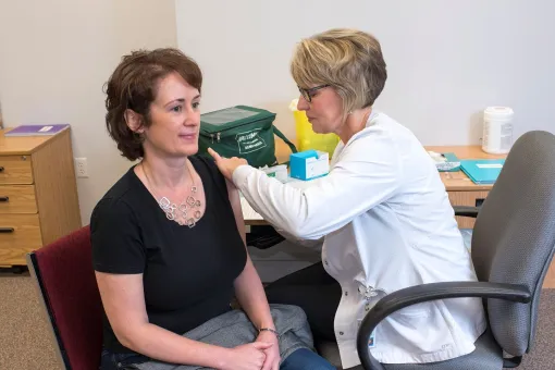 woman getting a needle from a nurse